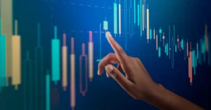 Hand interacting with glowing financial candlestick chart on a digital screen; represents trading analysis, strategy, and decision-making.