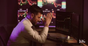 Stressed trader reacting to market losses while monitoring stock charts on multiple screens – concept of emotional investing and revenge trading